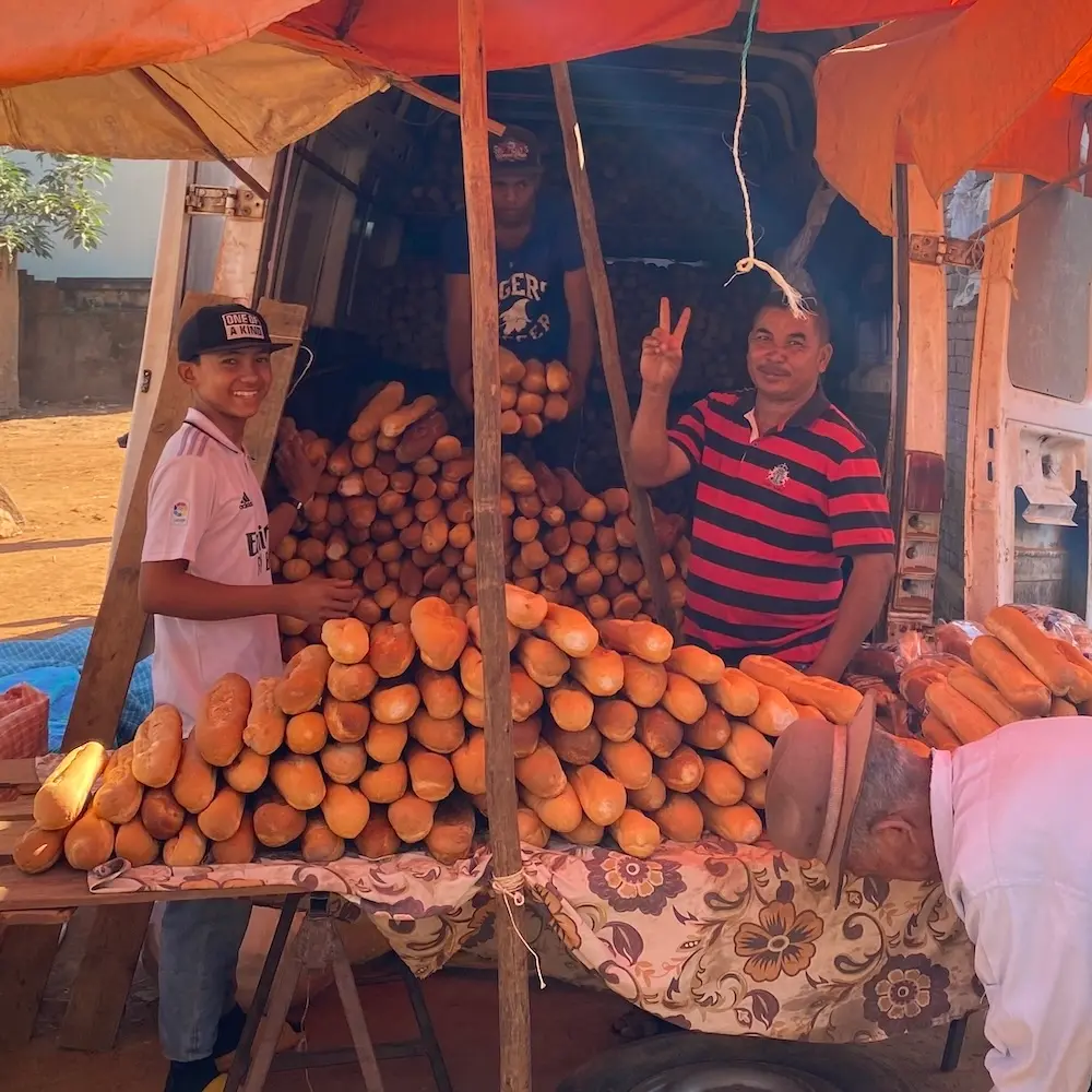 Händler in Madagaskar verkaufen Brot an einem Stand.