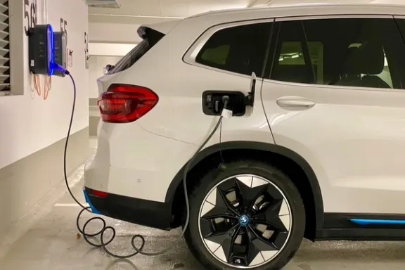 Ein elektrischer SUV lädt an einer Wallbox in einer Parkgarage