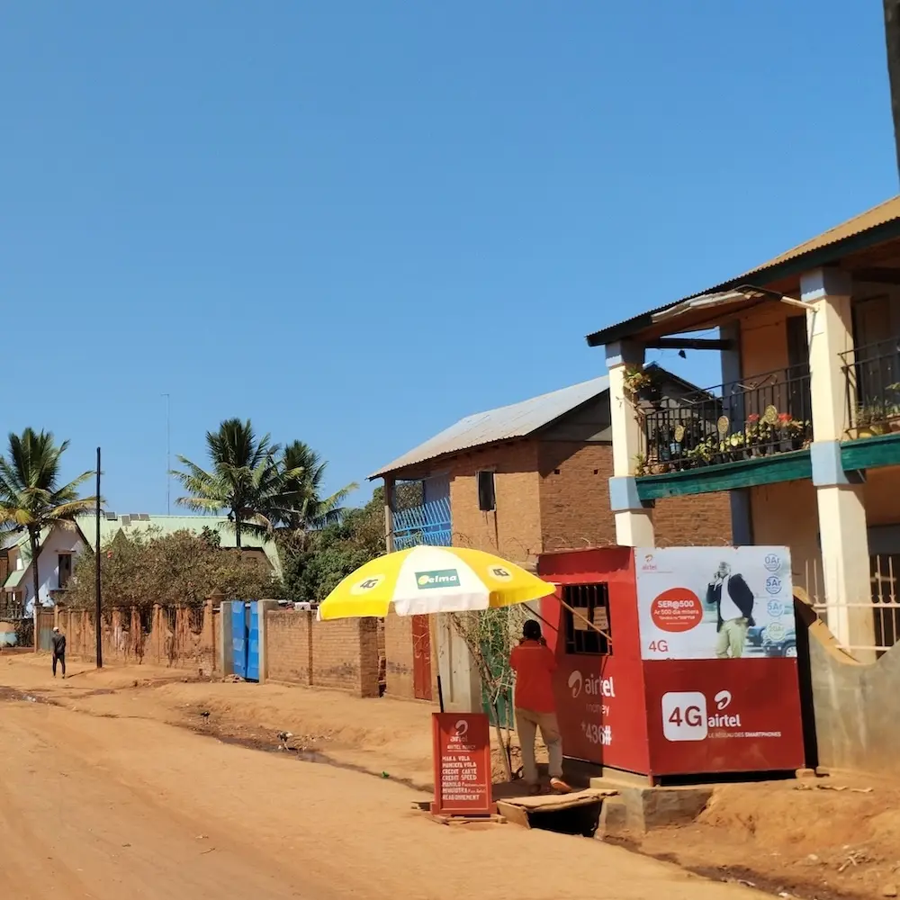 Straße in einem Dorf in Madagaskar mit einem kleinen Handy-Sim-Karten-Geschäft.