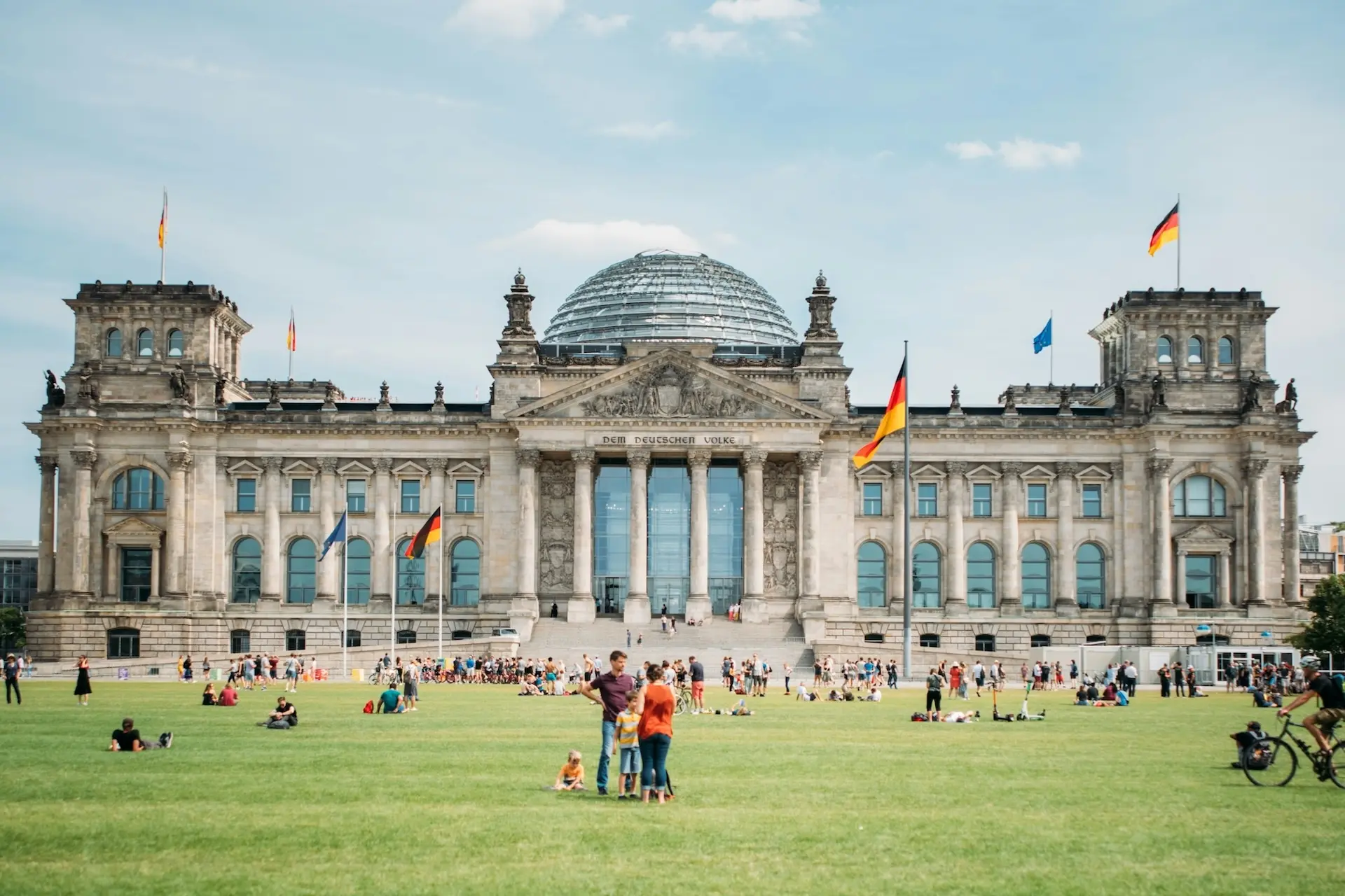 Menschen verweilen vor dem Reichstagsgebäude in Berlin