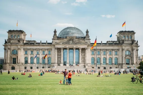 Menschen verweilen vor dem Reichstagsgebäude in Berlin