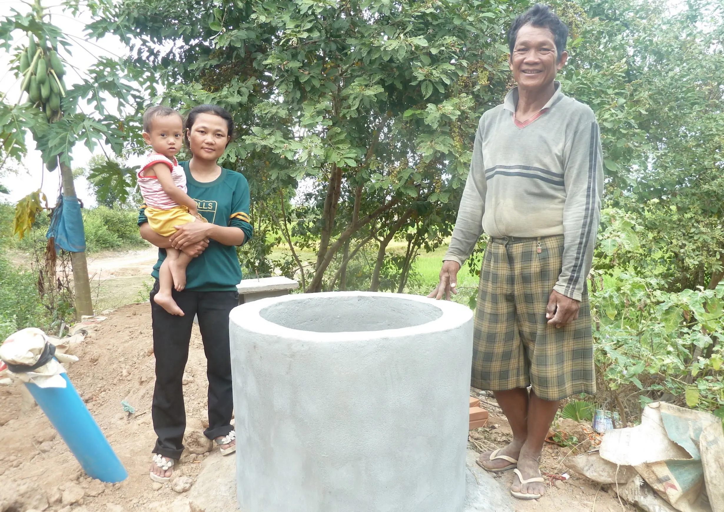 Frau mit Kind und Mann stehen neben Biogasanlage