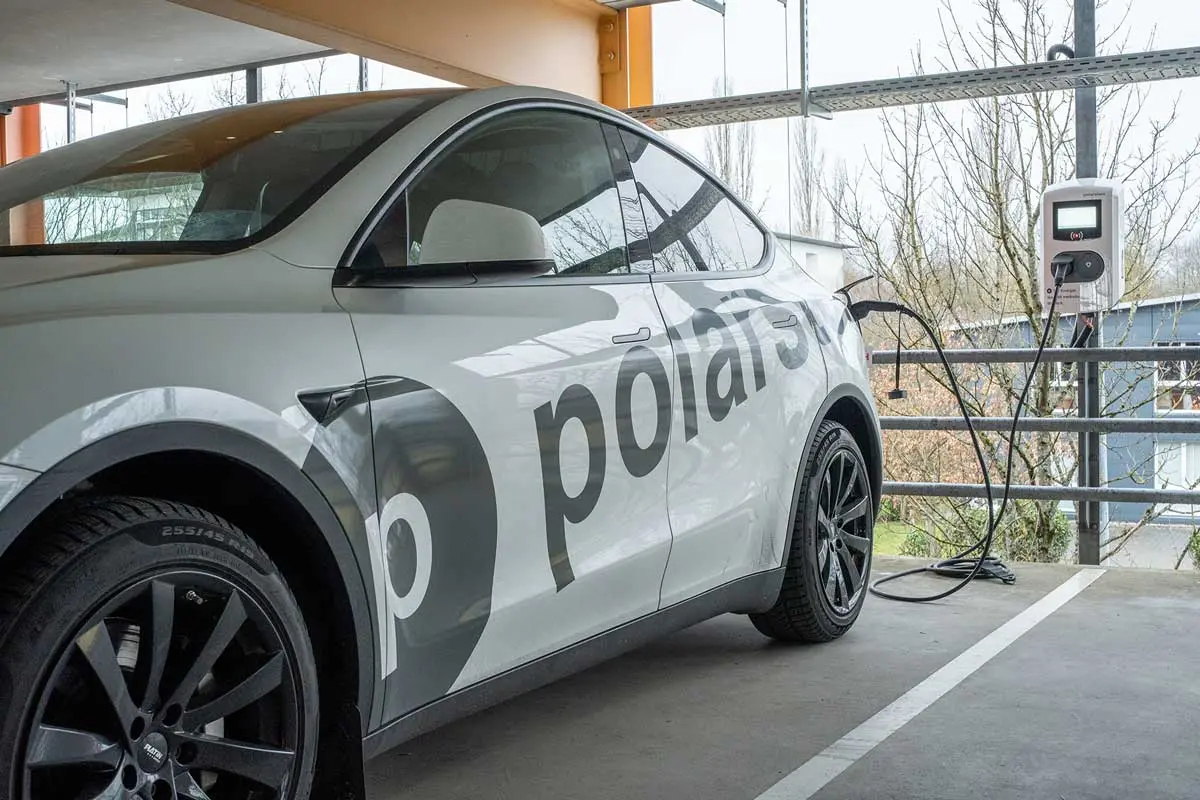 Ein weißes Elektroauto mit der Aufschrift „polarstern“ lädt an einer Ladestation im Parkhaus.
